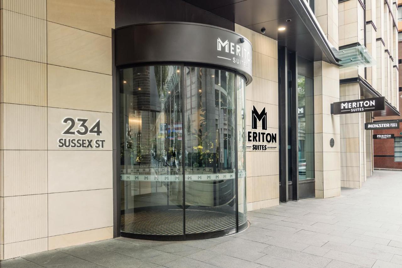 Meriton Suites Sussex Street, Sydney Buitenkant foto The photo shows the entrance of a building located at 234 Sussex Street. It features a modern glass revolving door, alongside a sign indicating "Meriton Suites." The facade is characterized by a combination of stone and glass elements, reflecting a c